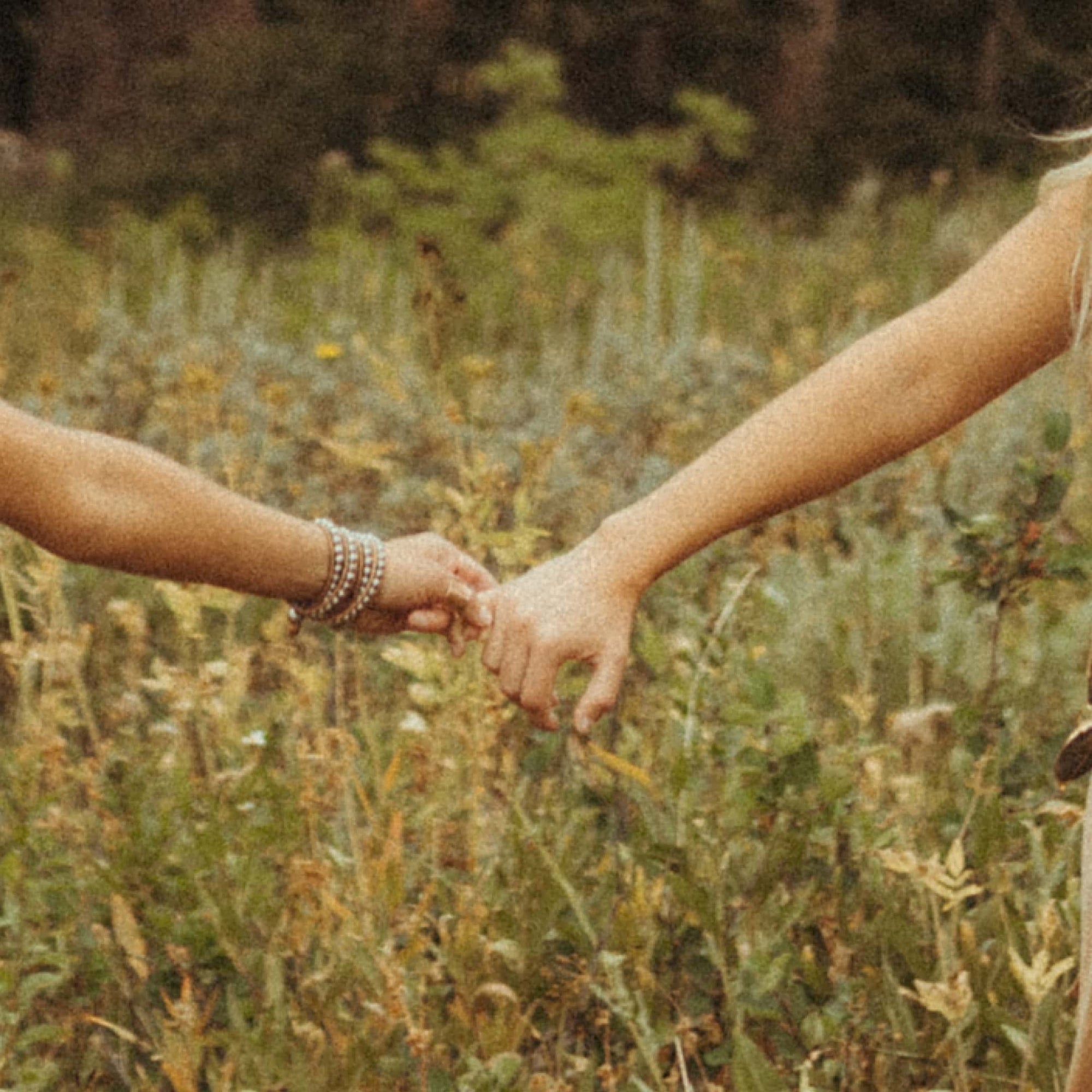 A close up of two people holding hands