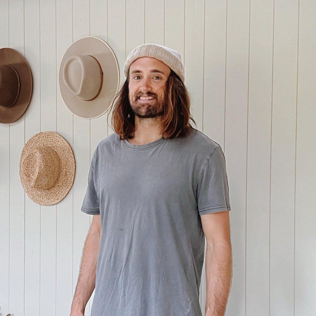 A man with medium length hair wearing a small fishermans wool beanie