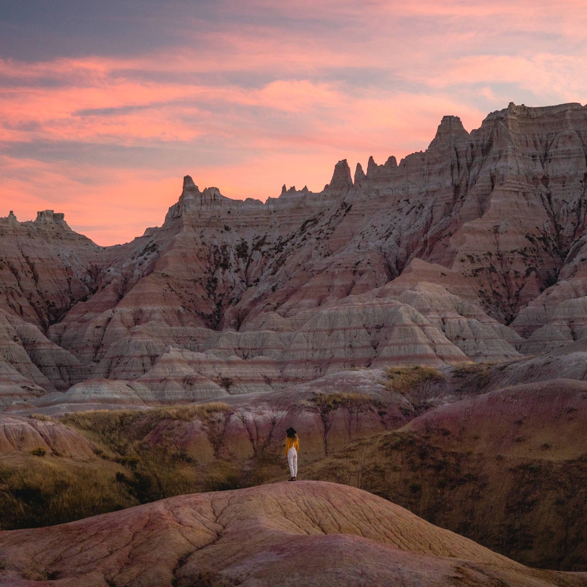 Chelsea standing in the middle of the Badlands looking towards all the large rock formations