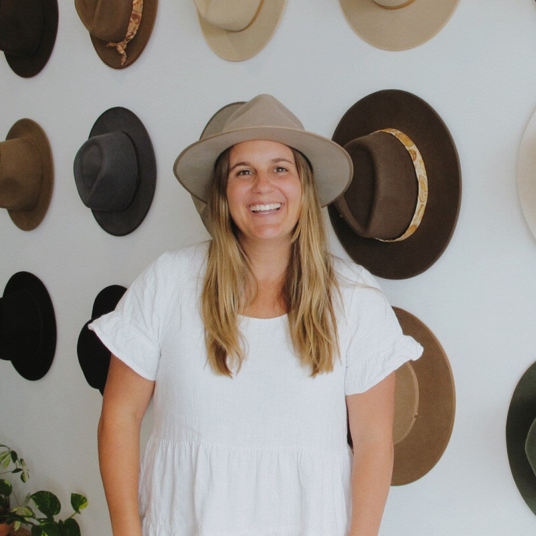 Woman with long blonde hair wearing a wide brim wool hat