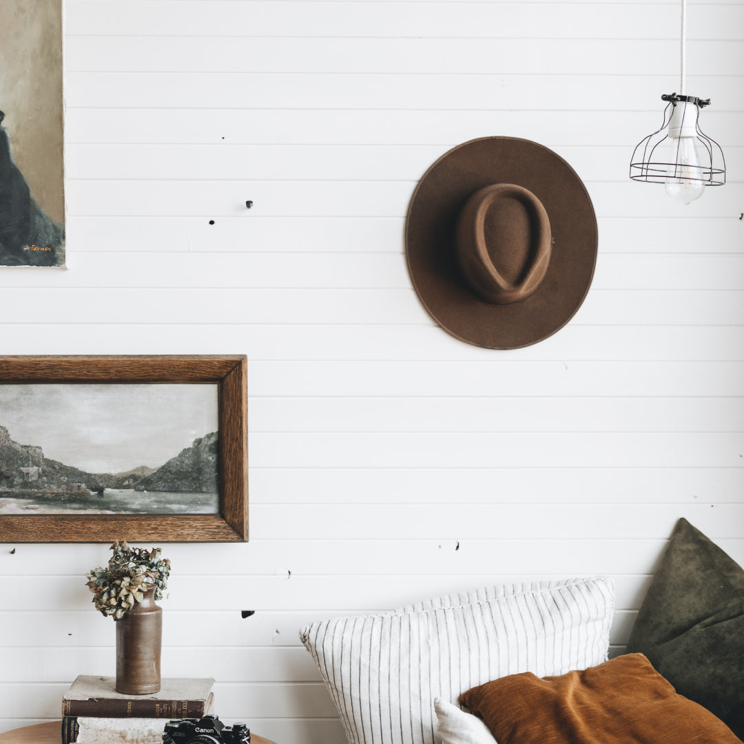 A hat on a wall of the inside of a rustic cabin