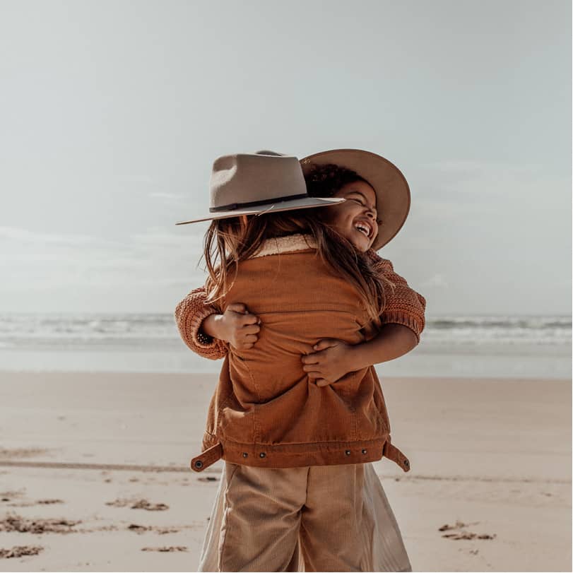 Two children hugging on the beach