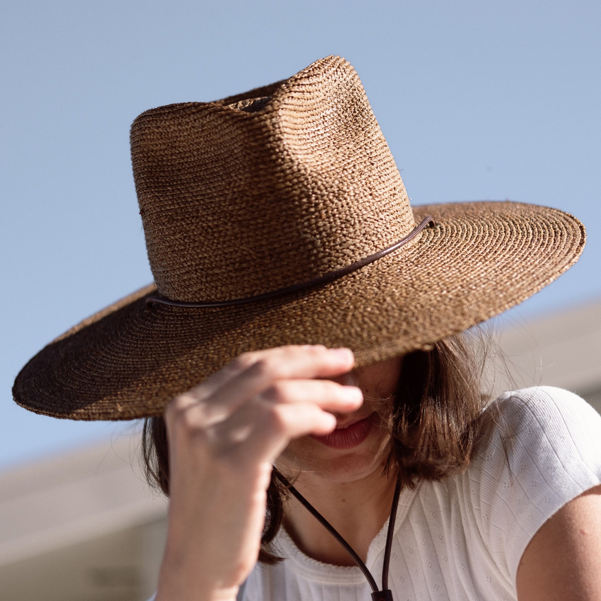 Close up photo of Lucette Romy wearing a wide brim straw hat