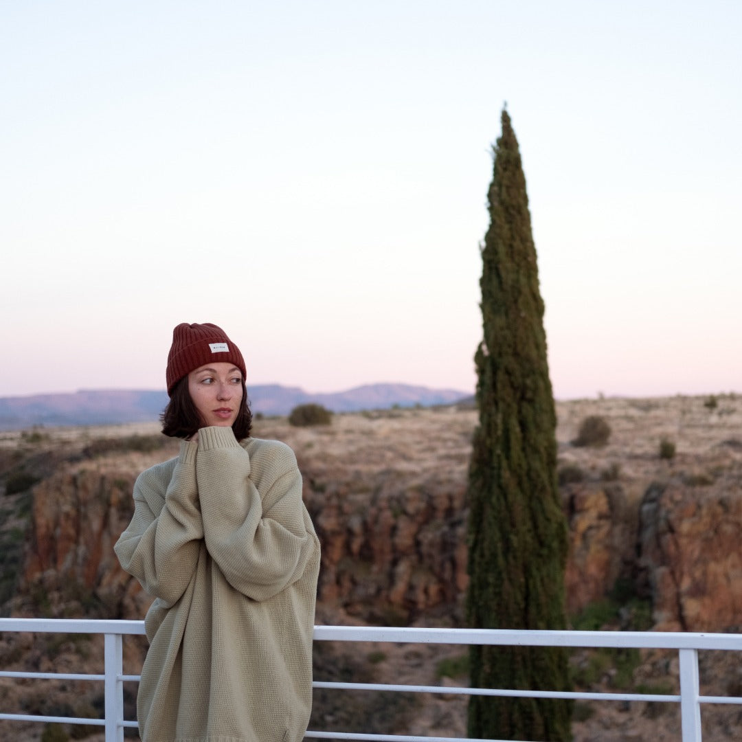Lucette standing outside in Arcosanti wearing a Levi wool beanie
