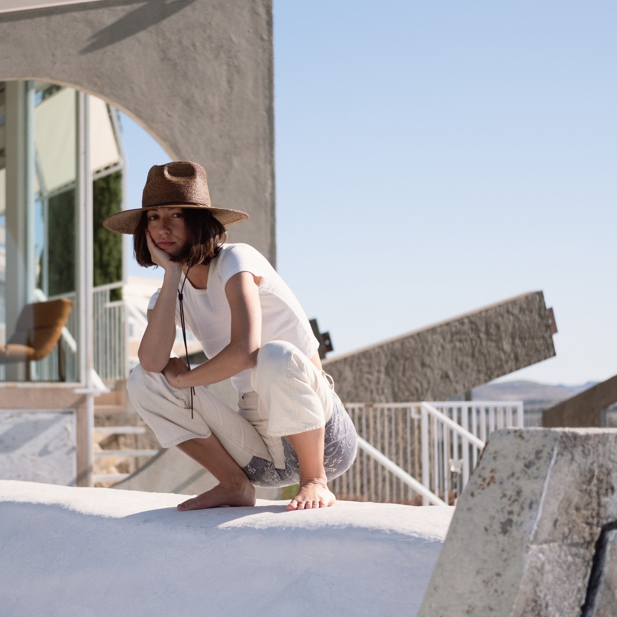 Lucette squatting on top of a ledge in Arcosanti