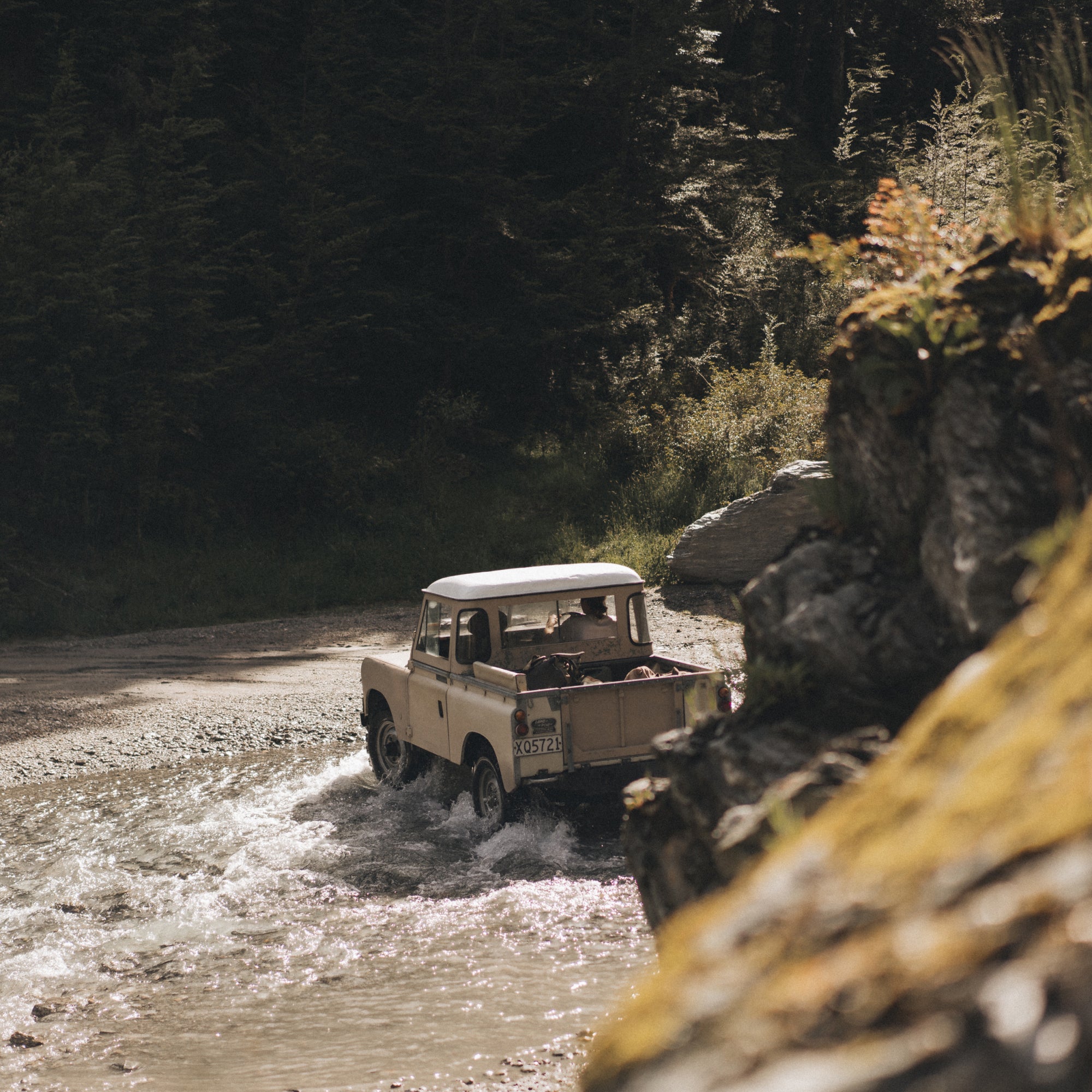 Loz and Alex driving their land rover through a water crossing in New Zealand