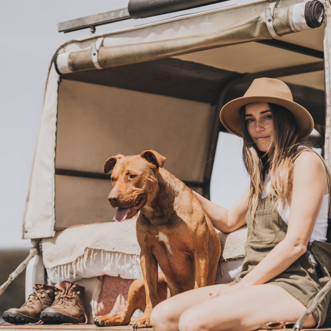 Lauren Williams sitting on the back of a truck with a dog