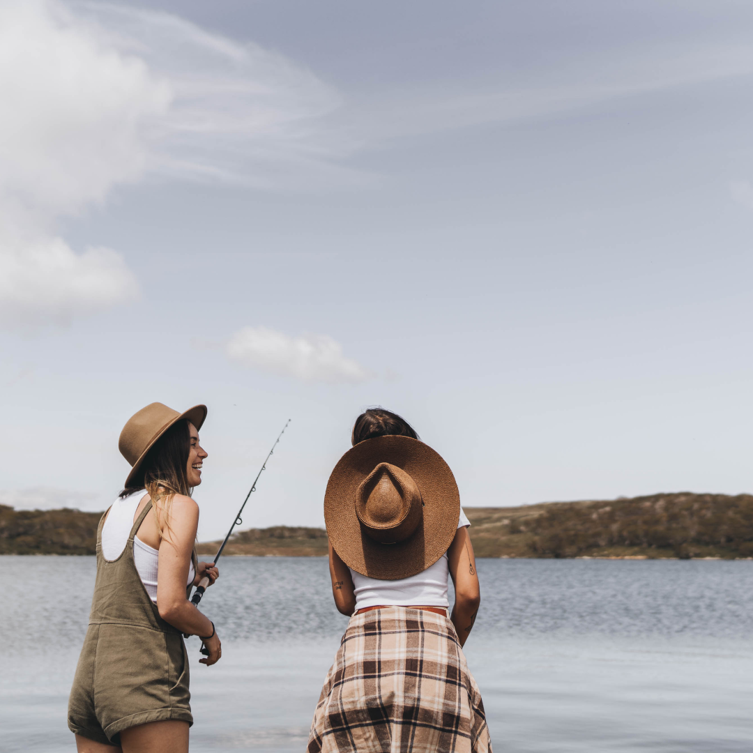 Two women fishing wearing wide brim sun hats