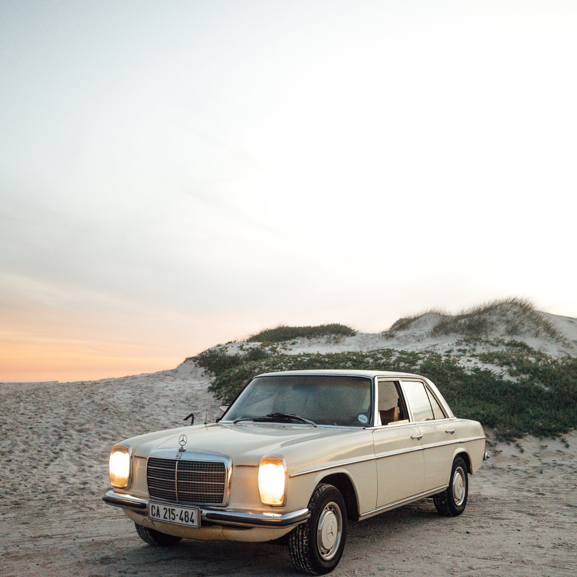 A classic vintage car parked on the sand of a beach in South Africa