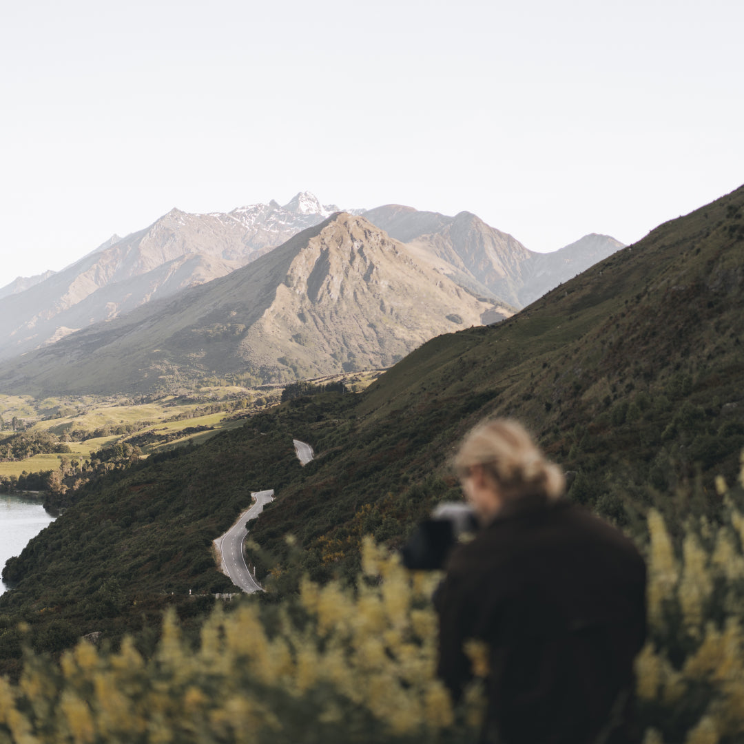 A man stands and looks at the mountainous view in front of him