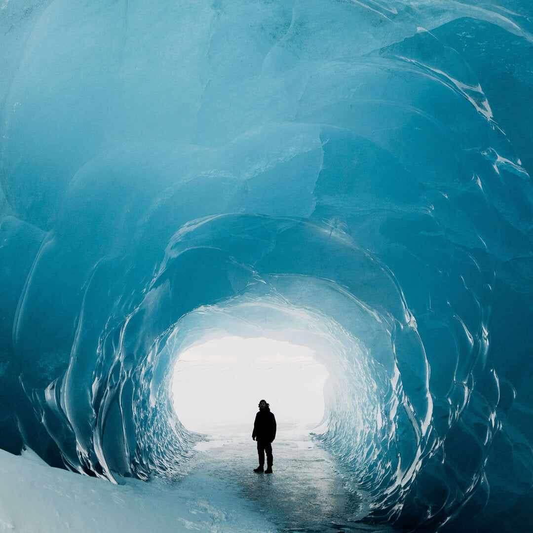 A person walking through the middle of an ice cave