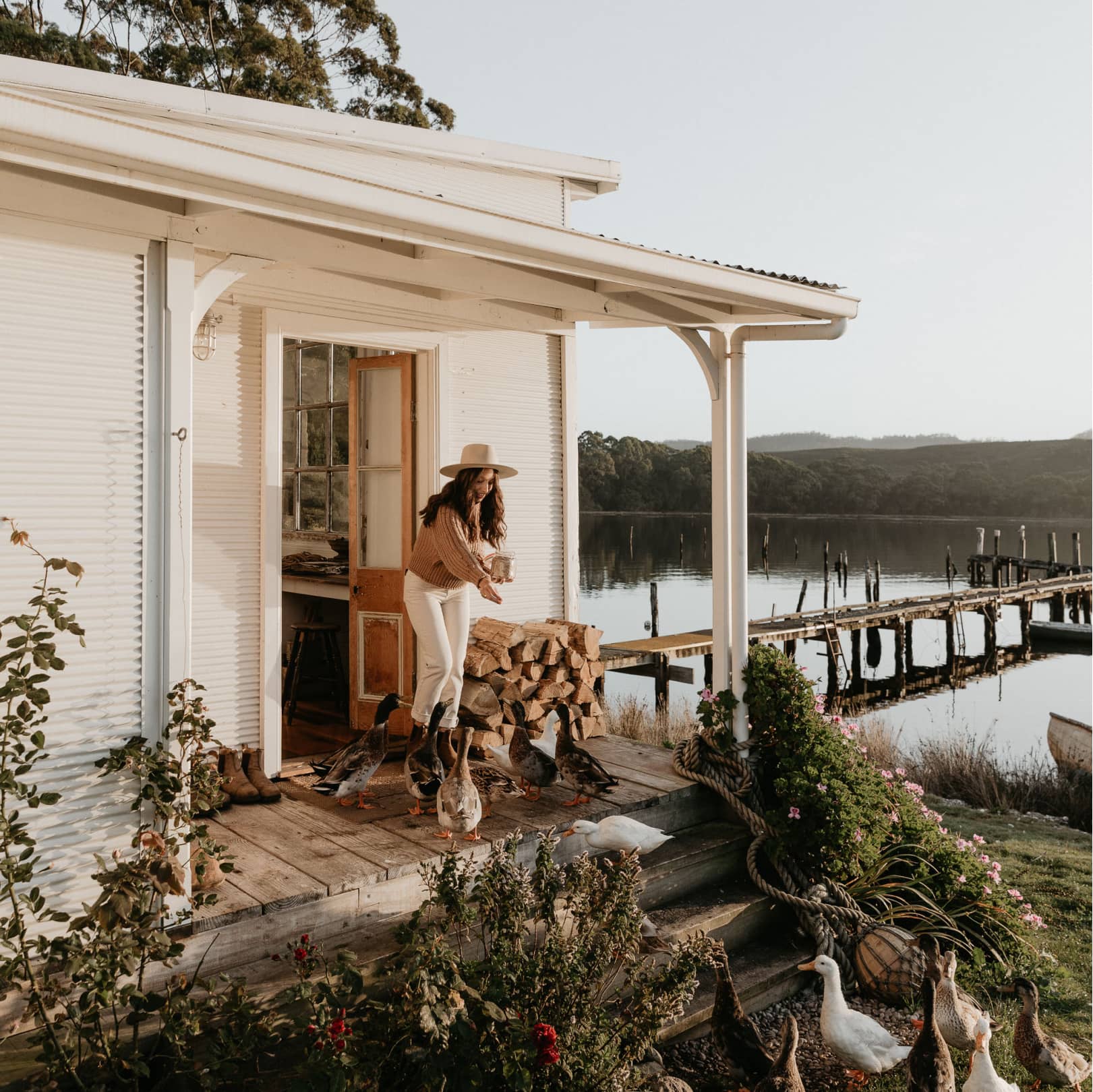 A woman feeding ducks on the deck of Captains Rest cabin