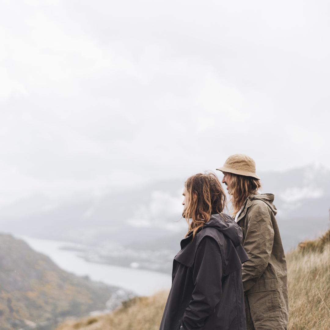 Alex and Stefan Haworth standing on top of a mountain peak looking out over the views of Queenstown