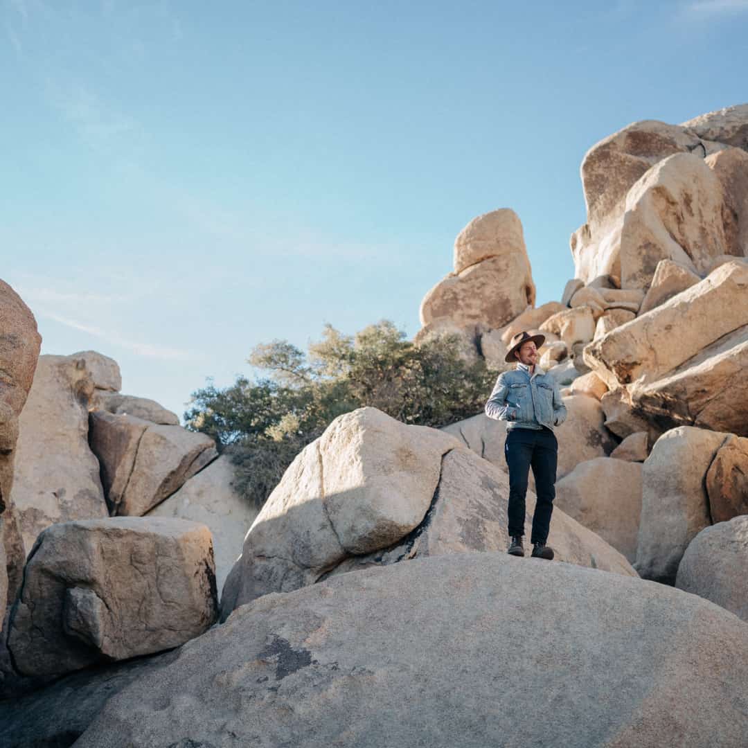 William standing on top of large boulders in Joshua Tree