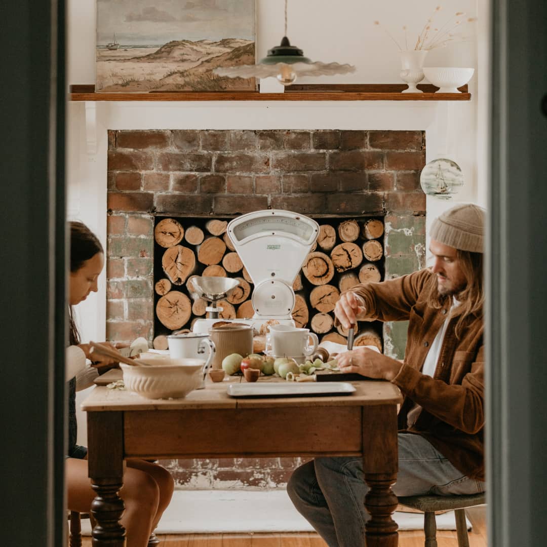 Two people preparing food inside The Burrows cabin