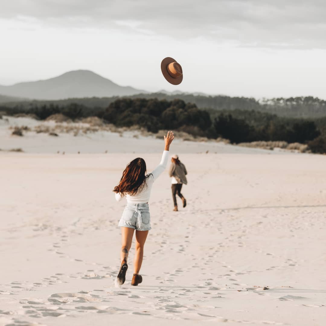 Two people running along the beach in Strahan, Tasmania