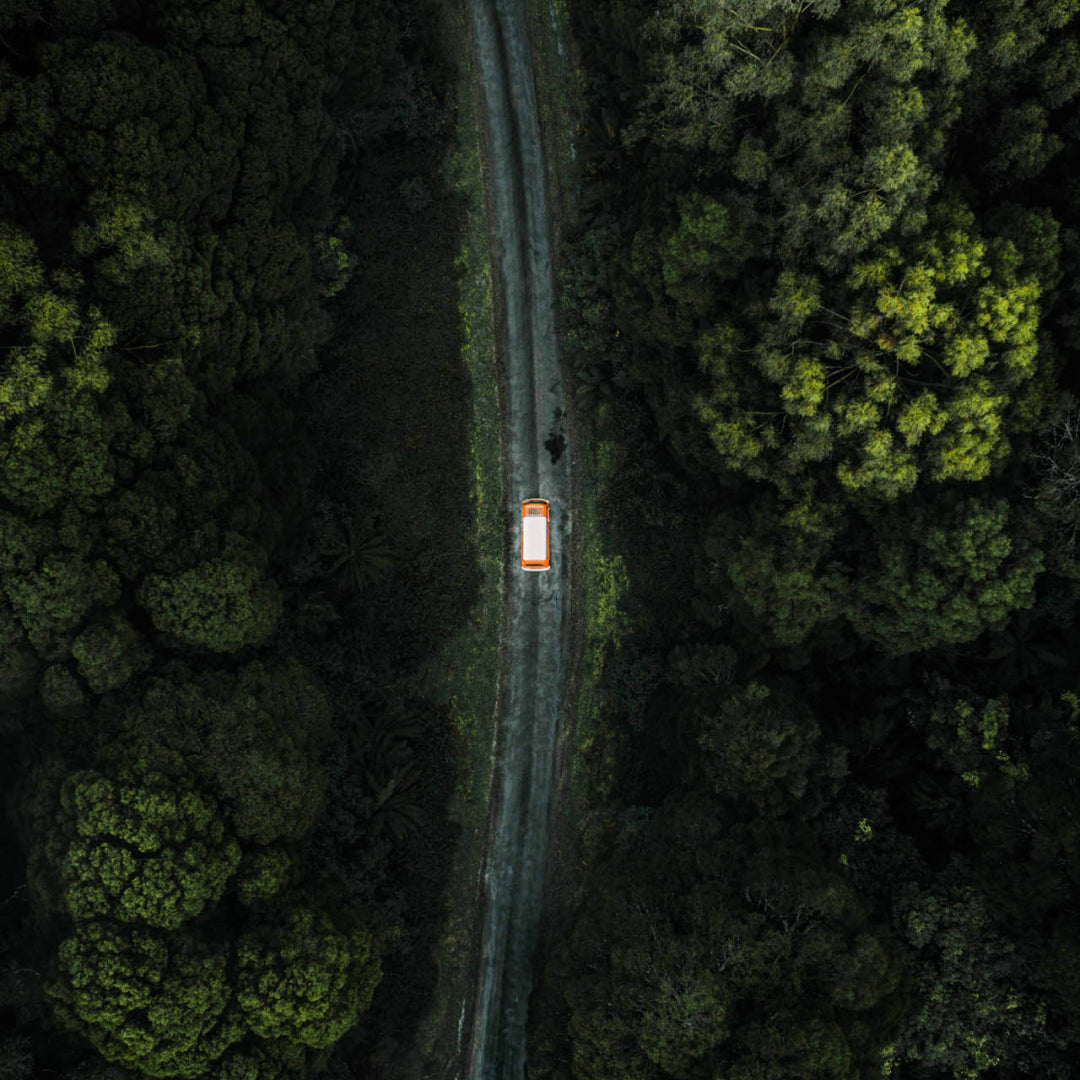 Aerial photo of a van driving on a road through trees