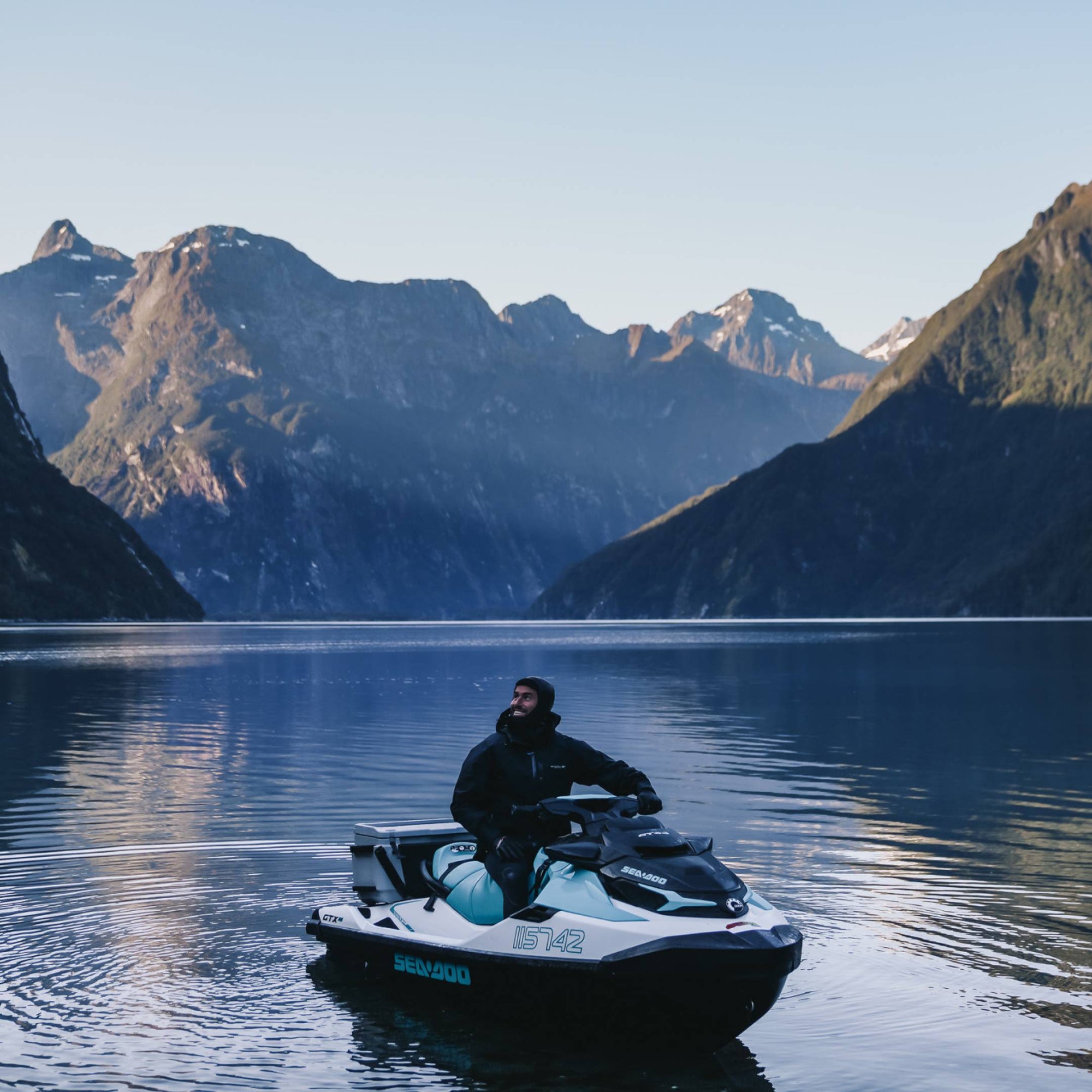 Marc on a jet-ski on a lake in the middle of snowcapped mountains