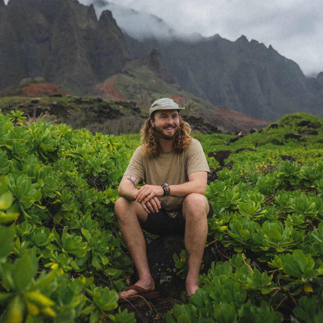 Brayden sitting amongst vegetation on the Nepali Coast hiking trail