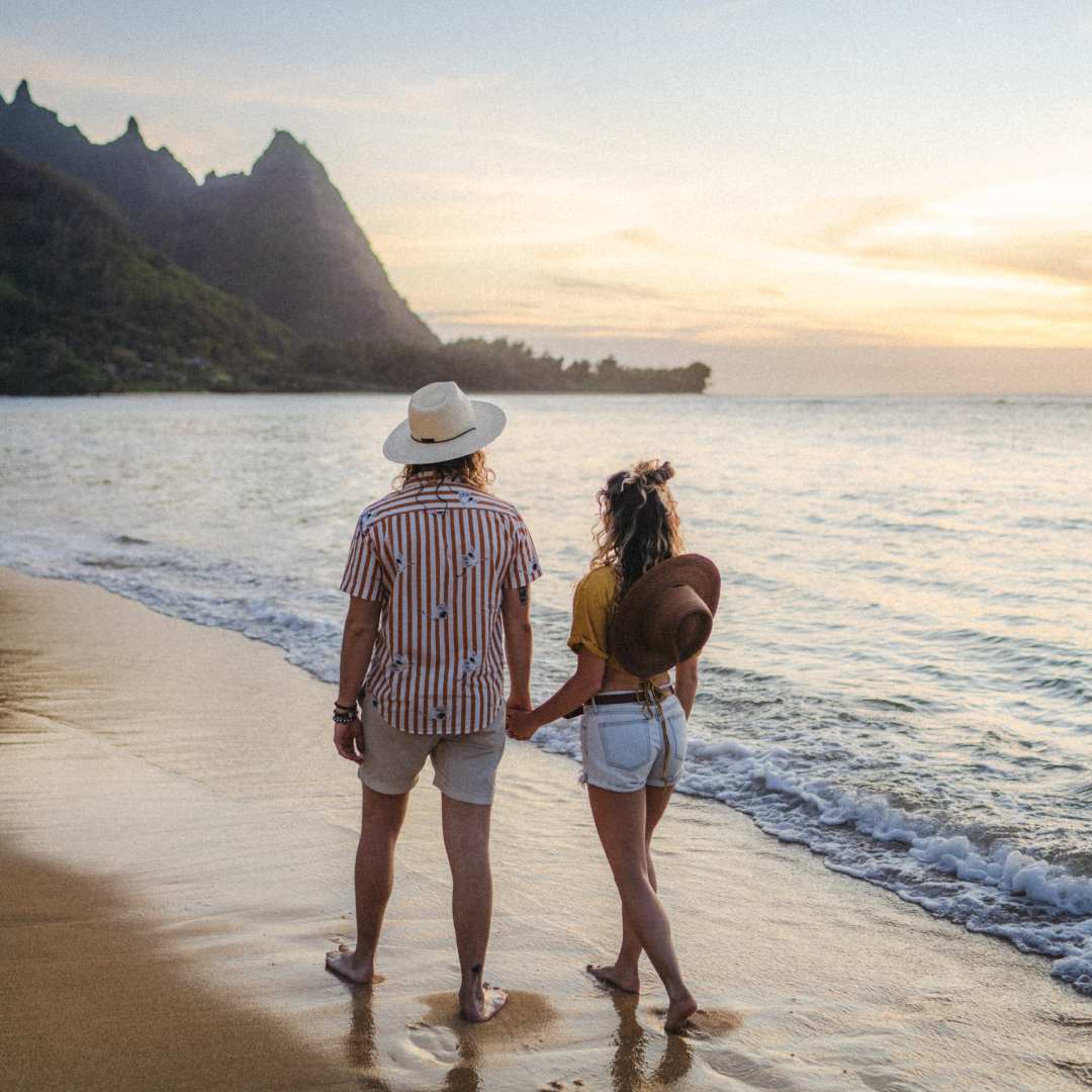 Chelsea and Brayden holding hands while walking along the beach