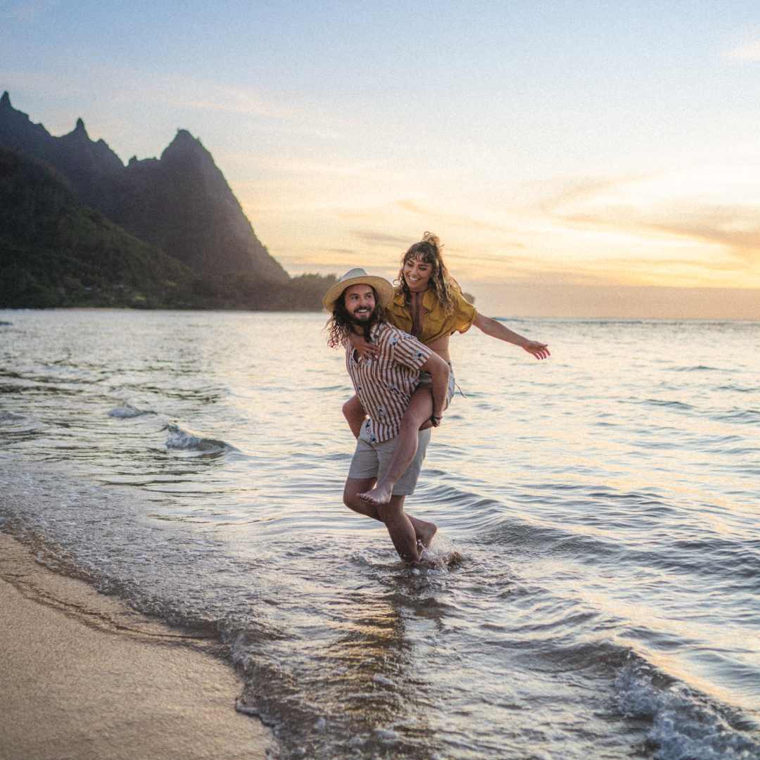 Brayden giving Chelsea a piggyback while walking along the ocean shore