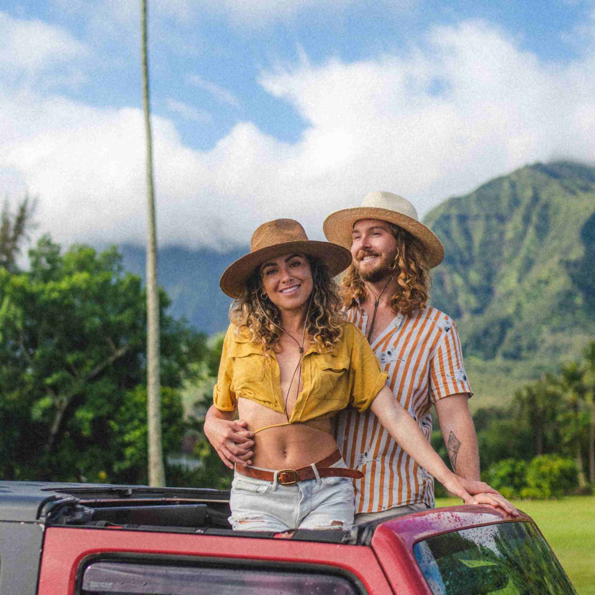 Chelsea and Brayden standing out the roof of a Jeep