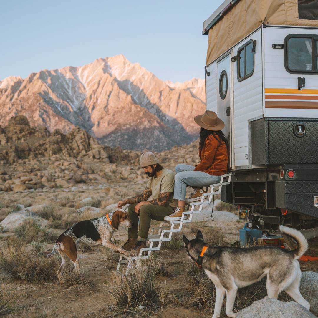 Rod and Blanca sitting on the steps of their camper parked in Utah