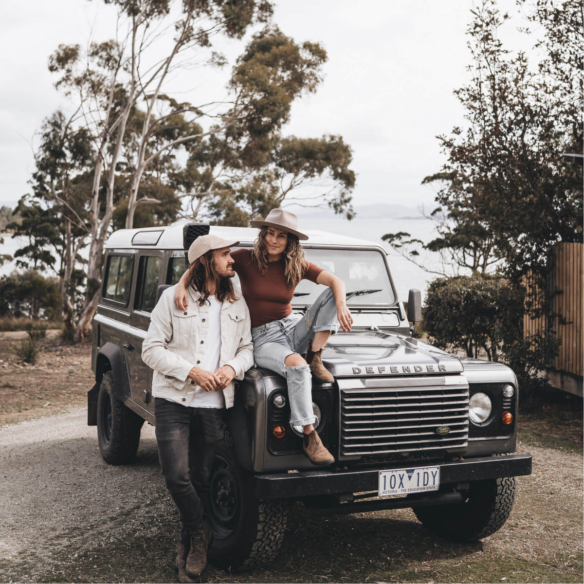 Alex and Lauren standing next to their Land Rover Defender