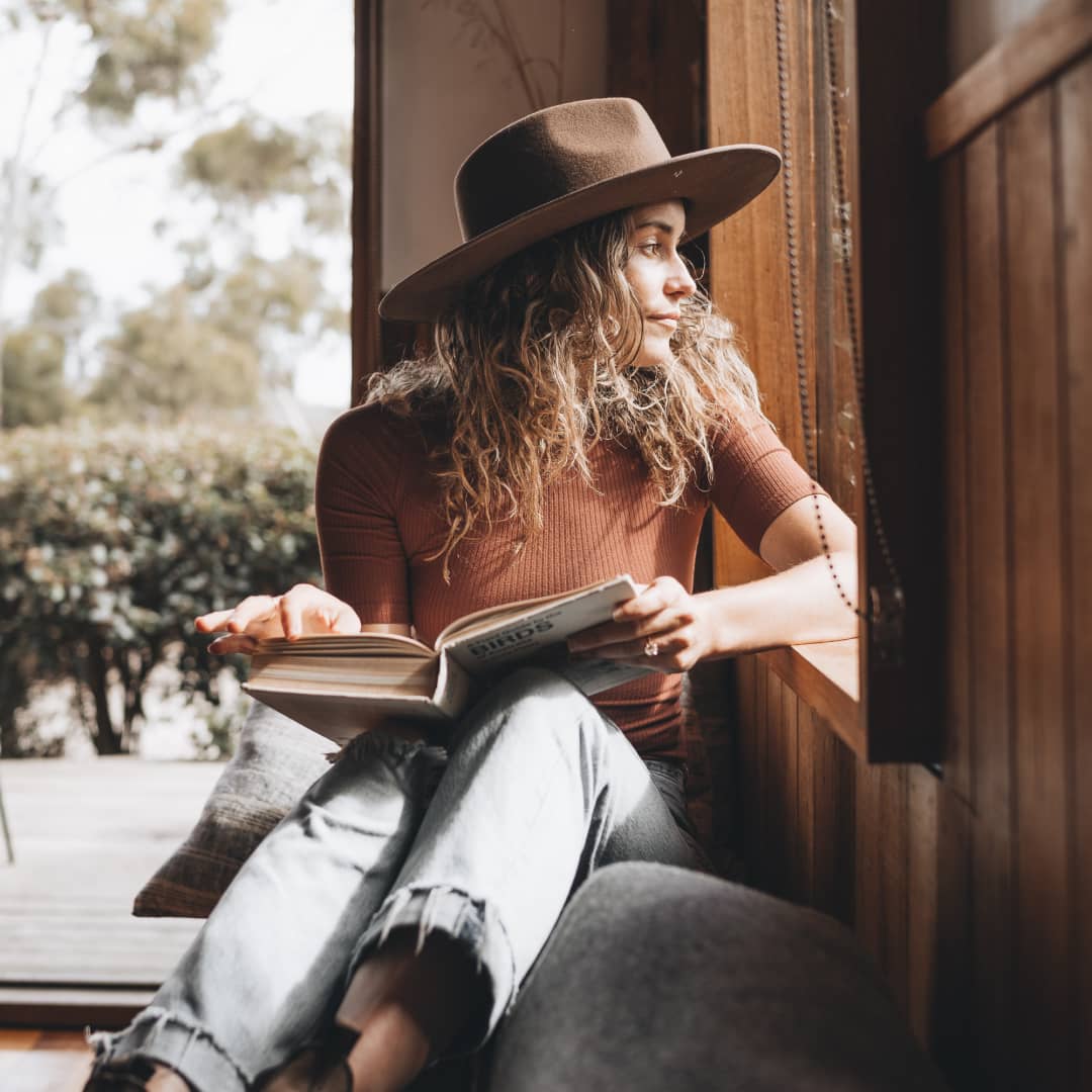 Lauren sitting in a nook reading a book