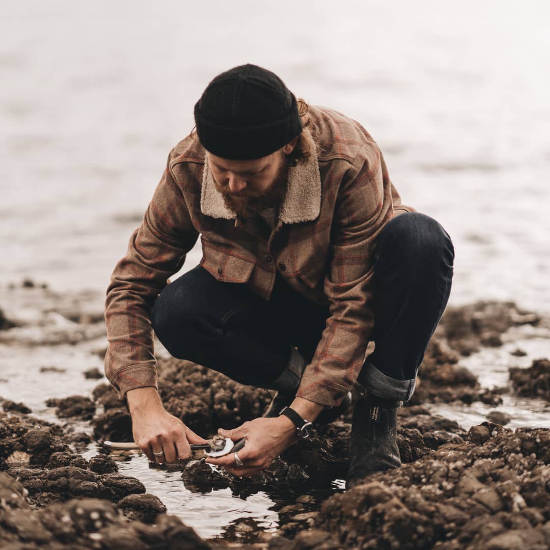 A man is catching fresh oysters and opening them