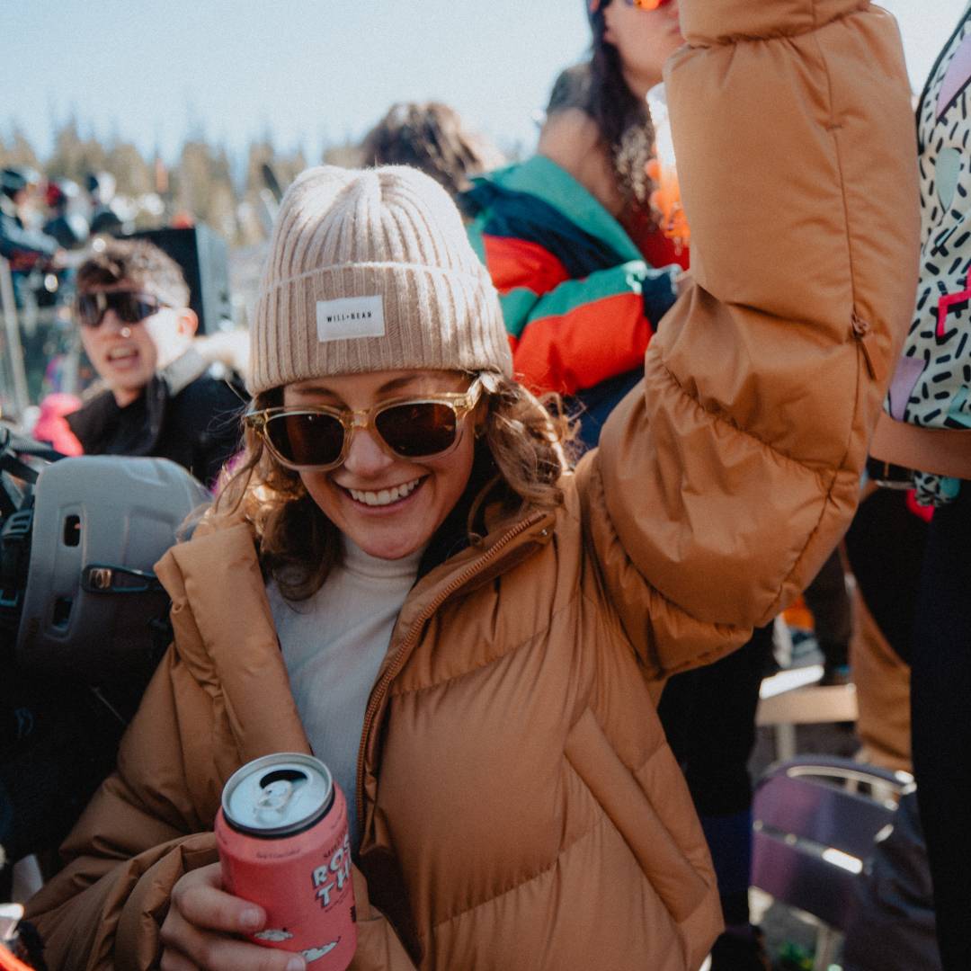 Woman with long, curly hair wearing a beanie at a skit resort party
