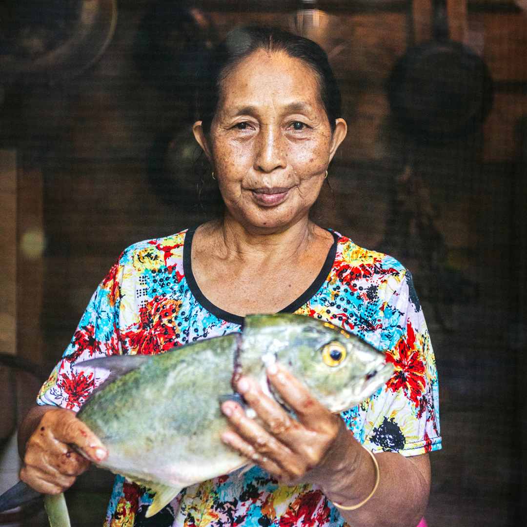 Mentawai local holding a freshly caught fish