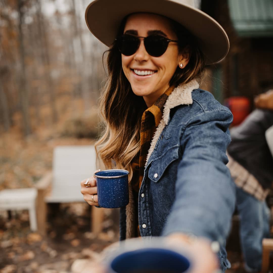 Amanda hands a cup of coffee to Taryn