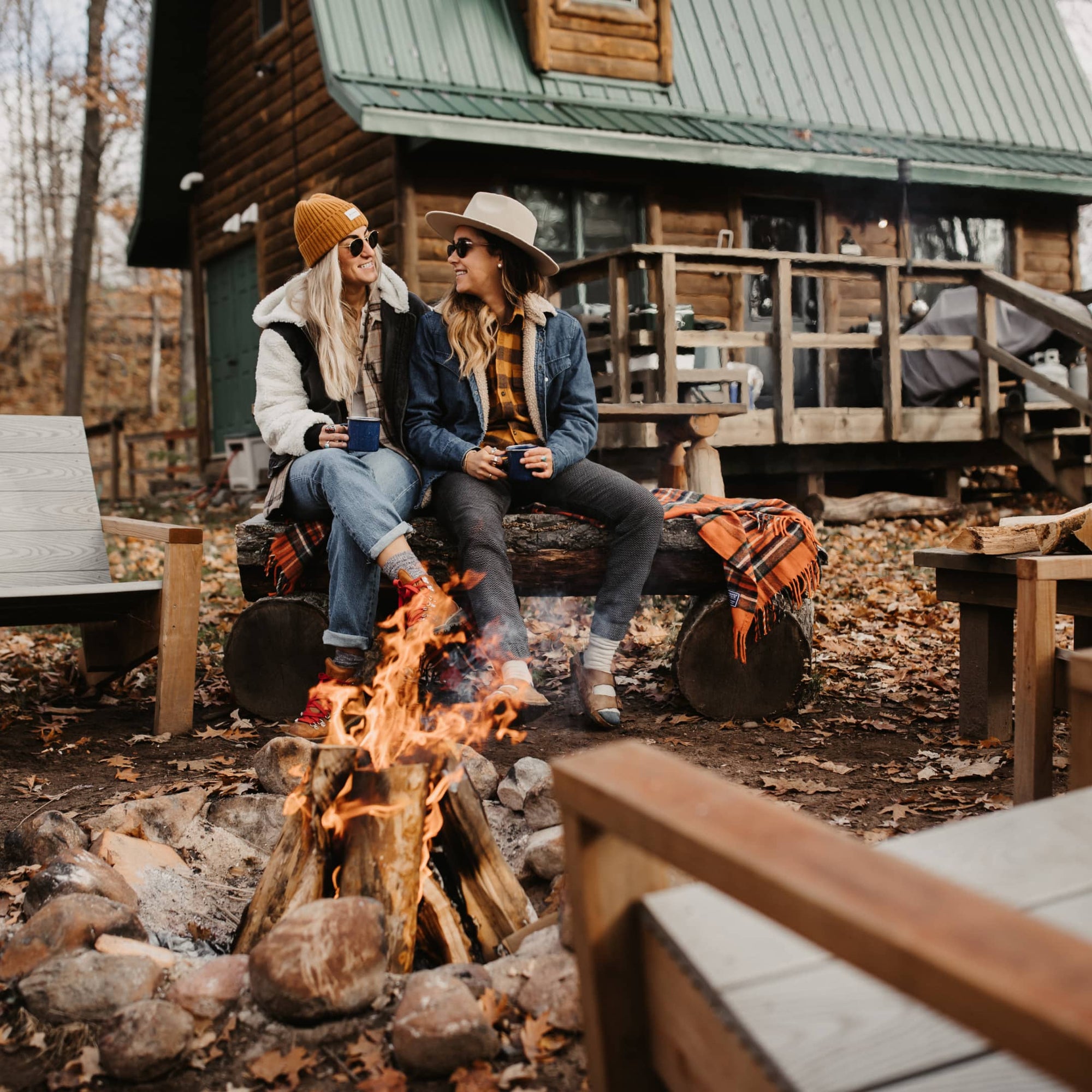 Amanda and Taryn sit by the fire-pit outside their lodge