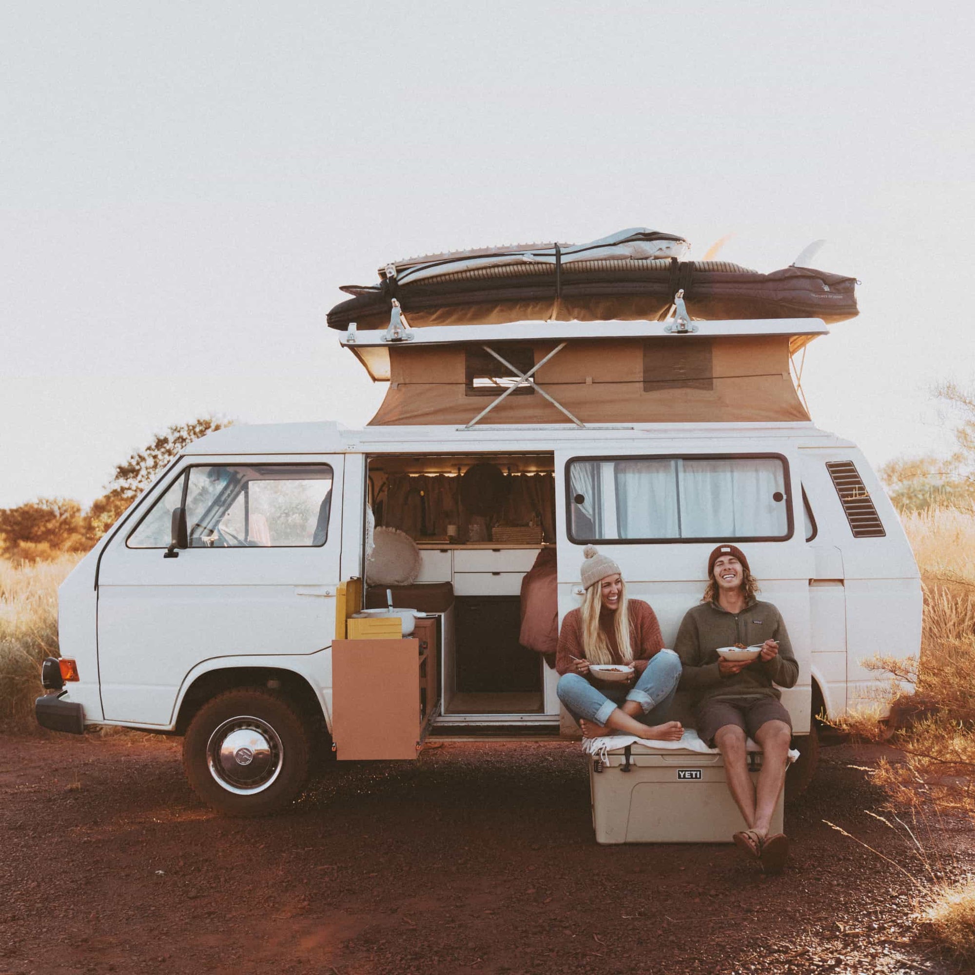 Kendall and Glenn siting on top of an esky next to their VW van Vance