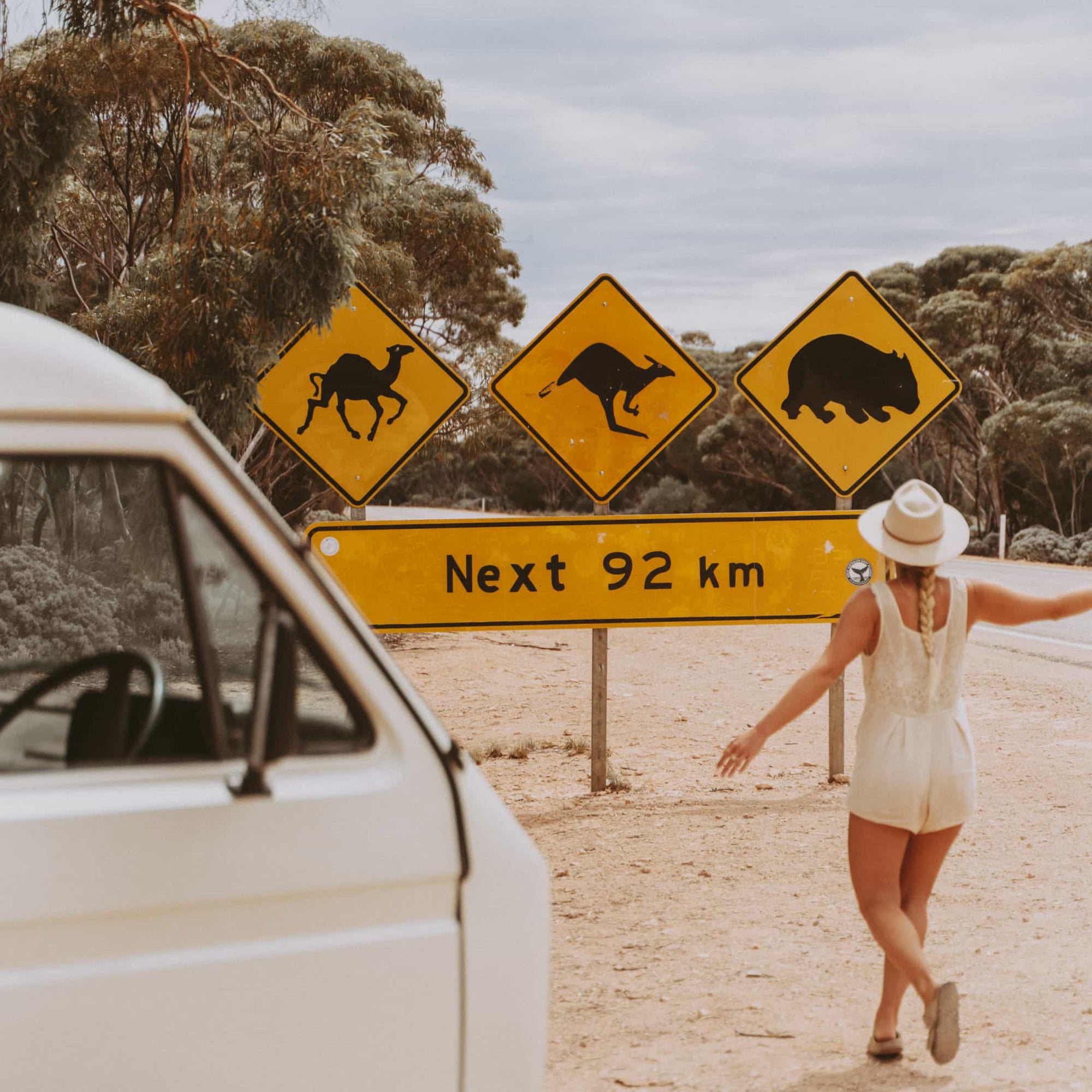 Kendall running towards a road sign warning of animals crossing in the area