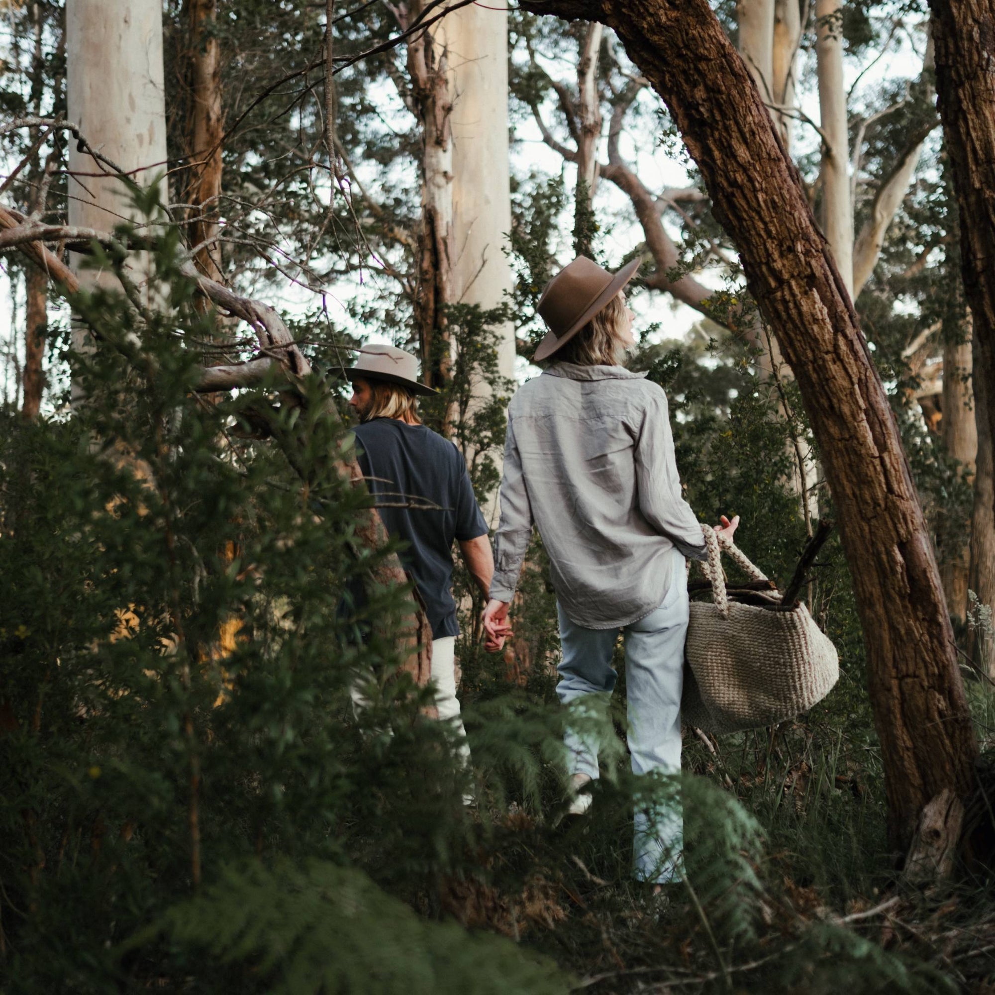 Rachel and her partner walk through bushland collecting kindling