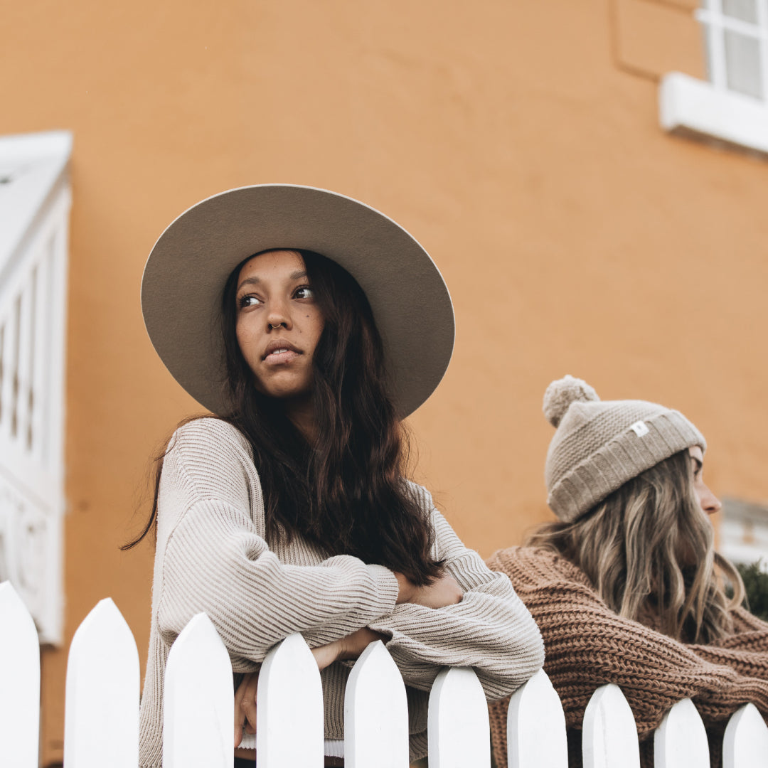 Two woman looking out over a white picket fence