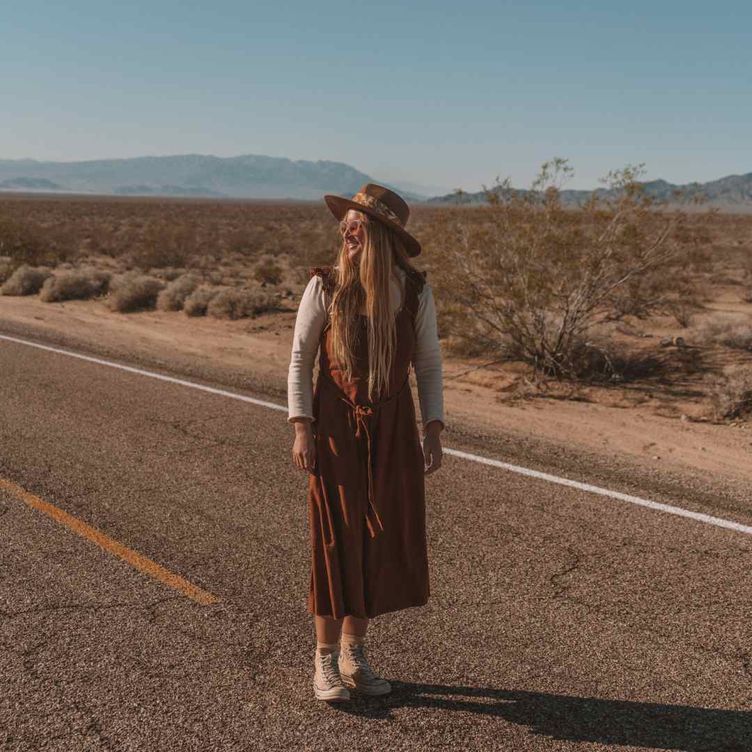 Sharnee walking along the road during her desert road trip