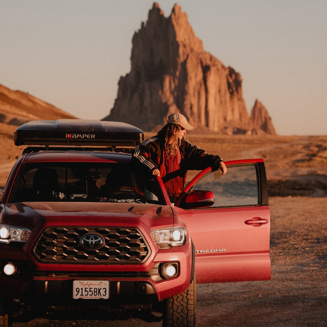 Brie leaning out the door of their sports utility vehicle in the middle of the desert