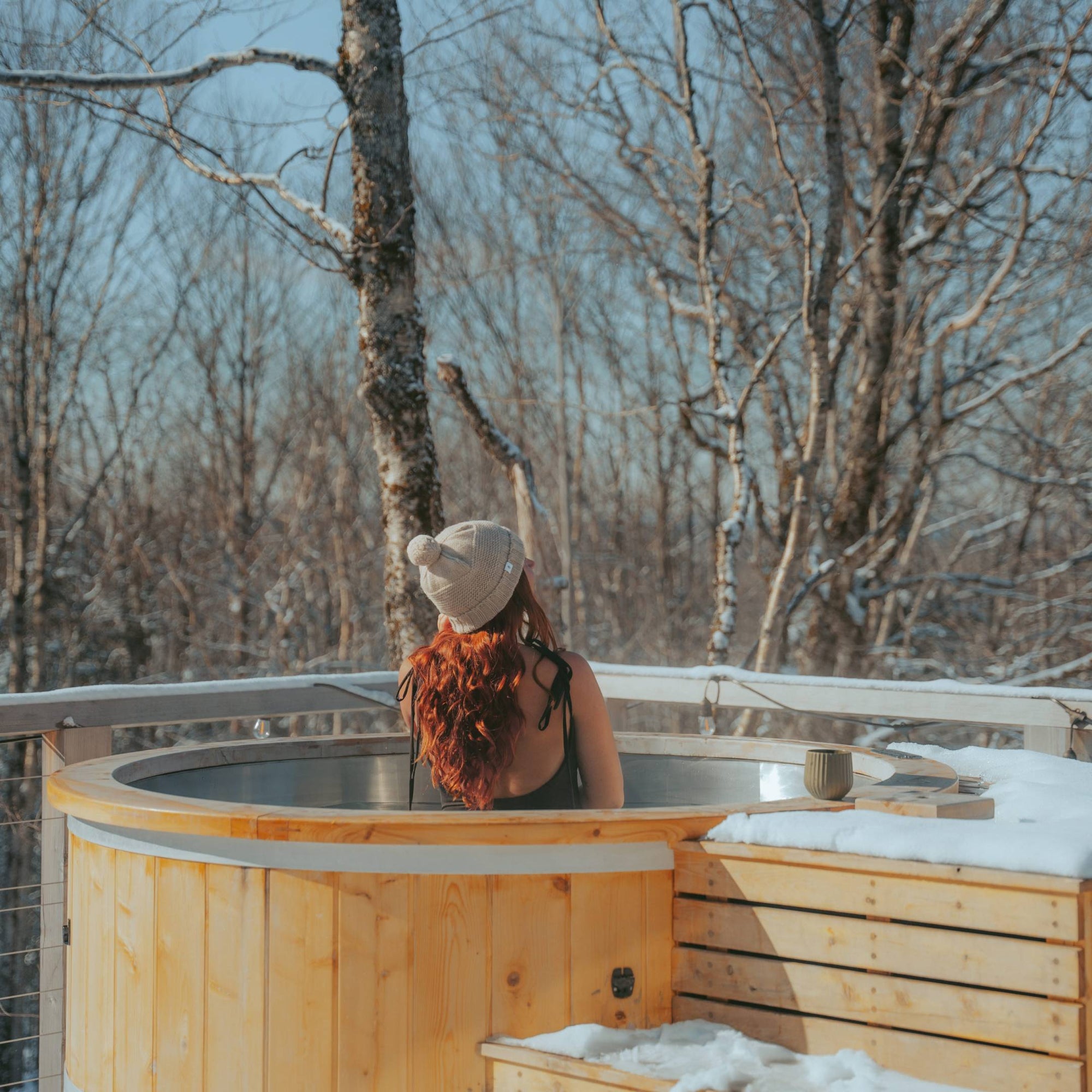 Jenna sits in the outdoor bath at The Hygge cabin