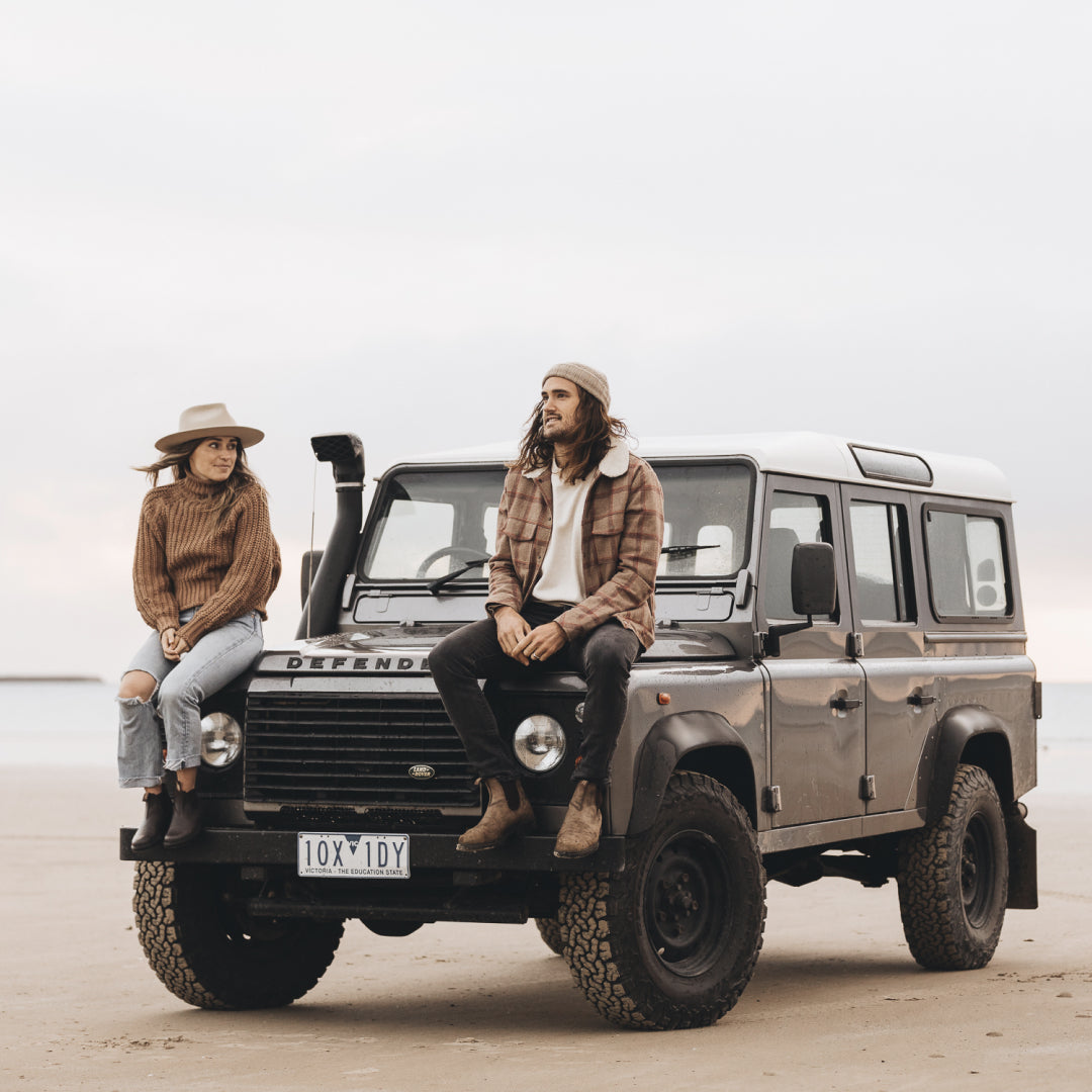 Loz and Alex sitting on the front of their Land Rover