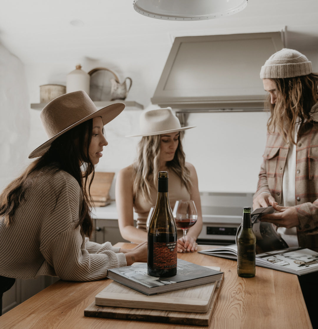 Three people looking at a book around the kitchen island