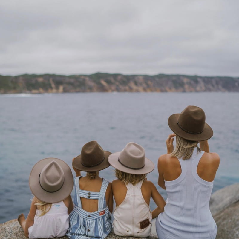 A mother and her three children sit together looking at the ocean