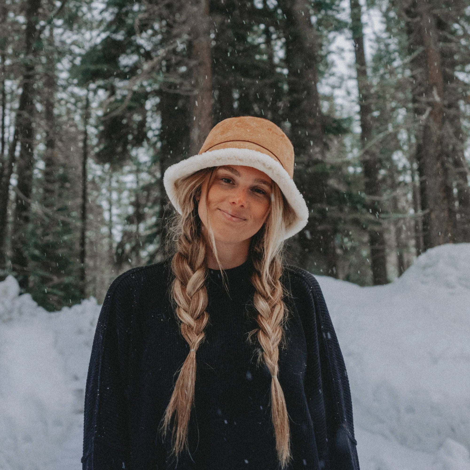 woman with long hair wearing a sherpa hat in the snow